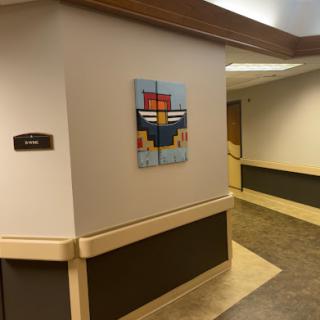 A vibrant abstract painting displayed on the wall of a hospital hallway, adding a touch of color to the environment.