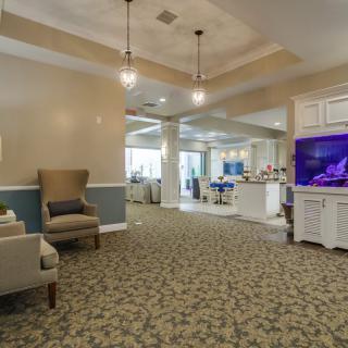 A spacious and well-lit lobby area featuring comfortable seating, an aquarium, and elegant decor.