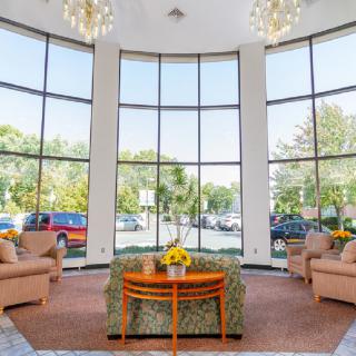A spacious lobby area with large windows, natural lighting, and comfortable seating arrangements.