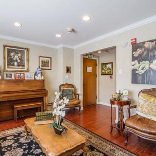 A cozy living room with traditional decor, featuring a piano and elegant furnishings.