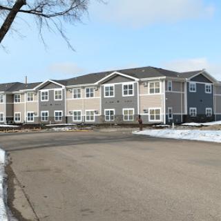A residential apartment building with a snowy landscape in winter.