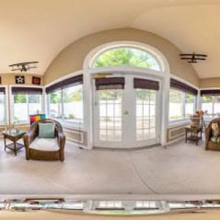 A bright and spacious sunroom featuring cozy furniture and large windows.
