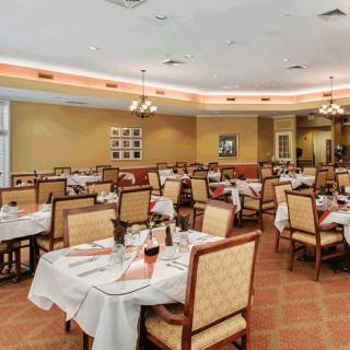 An empty restaurant dining area with neatly set tables and chairs.
