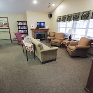A cozy living room with a seating area, television, and fireplace.