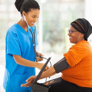 A nurse checks the blood pressure of a patient during a medical examination in a healthcare setting.
