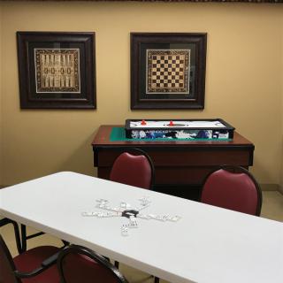 A game room featuring a chess board, framed artwork, and seating arrangement.