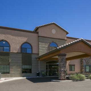 A modern hotel building with a welcoming entrance and large arched windows.