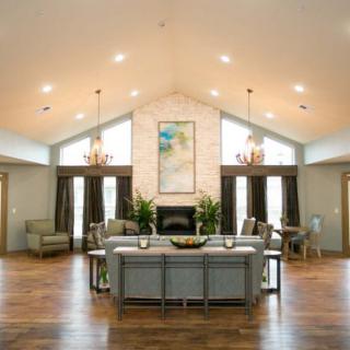 A spacious, modern living room with vaulted ceilings and elegant chandeliers.