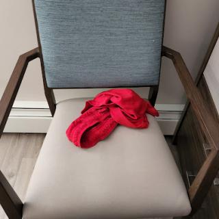 A red cloth draped over a minimalist chair.