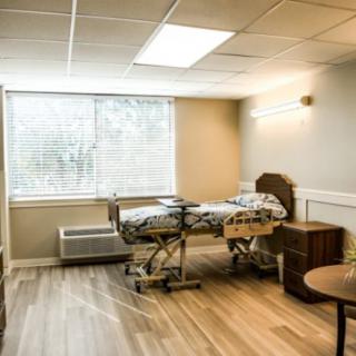 An empty hospital room with a bed near a window, creating a calm and clean atmosphere.