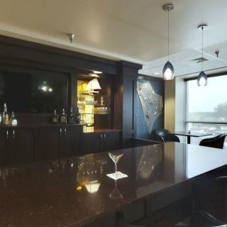A modern bar interior with a sleek countertop and ambient lighting.