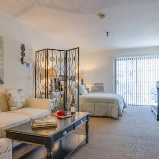 A cozy studio apartment with a combined living and bedroom area, featuring neutral tones and stylish decor.