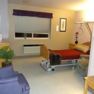A hospital room with a bed and medical equipment.