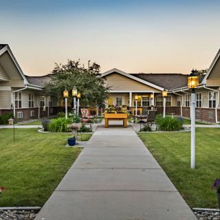 A peaceful residential building with a garden pathway at sunset.