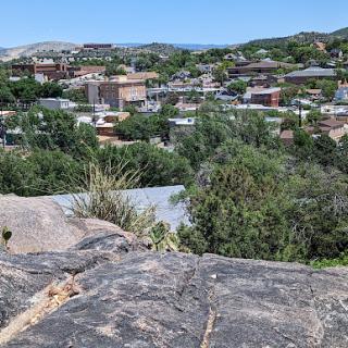 A panoramic view of a small town nestled among rolling hills, showcasing the blend of nature and urban life.
