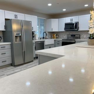 A modern kitchen with white cabinets and stainless steel appliances.