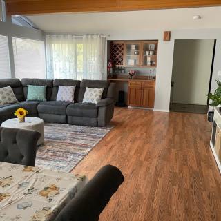 A cozy living room with a large sectional sofa, wooden floors, and a well-decorated interior.