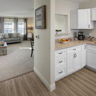 A modern open-space apartment featuring a kitchen and living room with bright, inviting decor.