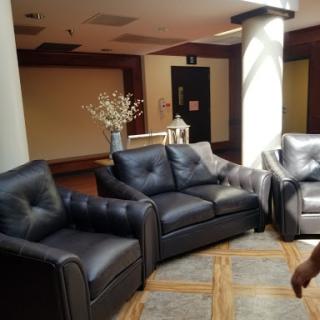 A set of stylish black leather sofas arranged in a modern lounge area.