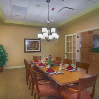 A formal dining room with a set table and elegant lighting.