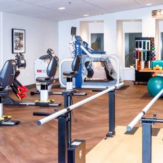 A well-equipped gym with various exercise machines and rehabilitation tools.