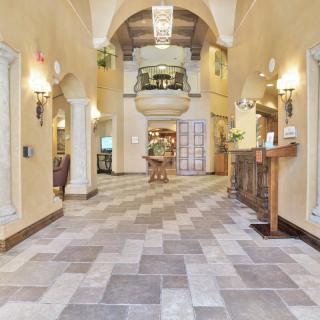 Elegant lobby with a vaulted ceiling and tile flooring.