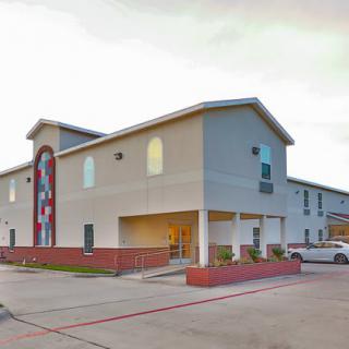 Exterior view of a motel with a parking area.