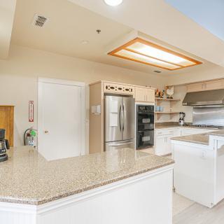 A modern kitchen with stainless steel appliances and a large countertop.