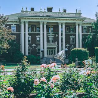 A beautiful historic building surrounded by vibrant rose gardens.