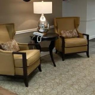 A cozy seating area with two armchairs flanking a small table and lamp.