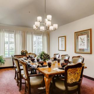 A well-decorated dining room with a wooden table, elegant chairs, and a chandelier.