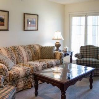 A cozy living room with patterned furniture and a wooden coffee table.