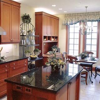 A spacious kitchen with wooden cabinets, granite countertops, and an adjoining dining area.
