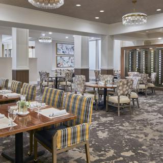 A well-appointed restaurant dining area with stylish furniture and elegant chandeliers.