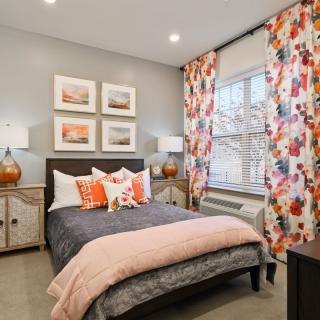 A cozy bedroom with vibrant curtains and modern decor.