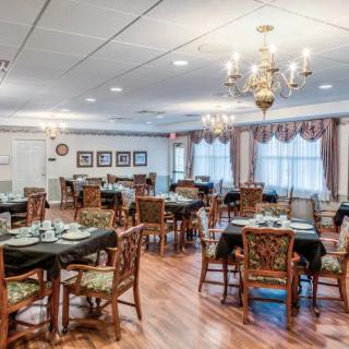 An elegant dining room with beautifully set tables and chandeliers.