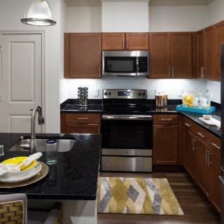 A modern kitchen featuring stainless steel appliances and wooden cabinetry.
