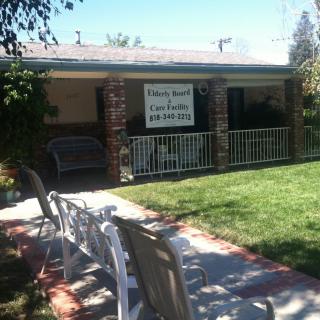A cozy house with a front porch showcasing a 'For Rent' sign.