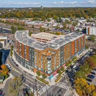 Aerial view of a large urban building situated at an intersection in a bustling commercial area.