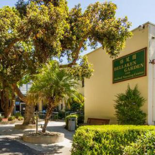 Exterior view of a hotel surrounded by lush landscaping and trees during the daytime.