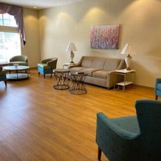 A cozy living room with a sofa, armchairs, and decorative lighting.