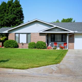 A charming suburban home with well-maintained greenery and a welcoming front porch.