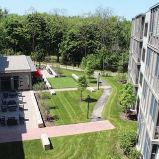 A view of an apartment complex with landscaped gardens and pathways.
