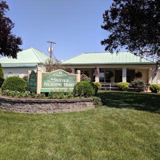 A well-maintained building with a green roof surrounded by landscaped gardens.