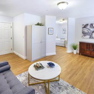 A modern living room with minimalist decor, featuring a sofa, a round coffee table, and wood flooring.