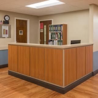 A modern reception area with a wooden counter, ideal for healthcare settings.