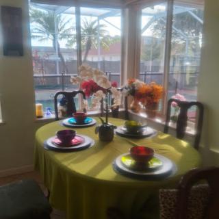 A vibrant dining area with a colorful table setting and a beautiful view outside.