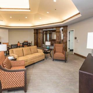 A cozy lobby area featuring comfortable seating with sofas and chairs, accentuated by warm lighting.