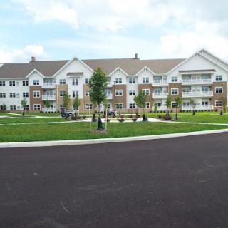 A modern apartment complex surrounded by a landscaped green area.