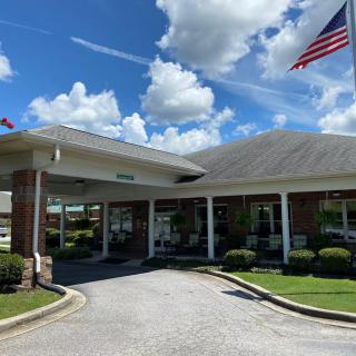 A building entrance with an American flag and a clear, cloudy sky.